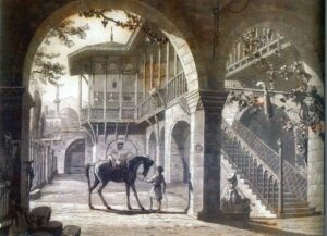 Απεικονίζει ημιυπαίθρια στοά με καμάρες, παραδοσιακό σαχνισί (προεξοχή ορόφου με ξυλοδεσιά), μια εξωτερική σκάλα, έναν άνδρα που κρατά άλογο και έναν καθιστά άνδρα να καπνίζει.
